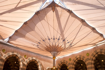 MEDINA, SAUDI ARABIA - APRIL 28 2018: These Umbrella construction on the square of Al-Masjid An-Nabawi or Prophet Muhammed Mosque are protecting people from sun at daytime and work as lights at night