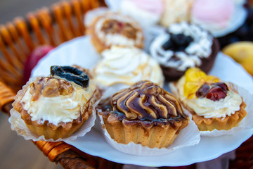 Cakes in the basket. Sweets. Sweet dessert in the nature.