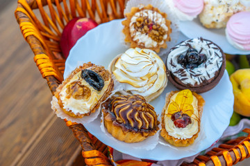 Sweet dessert on a white plate. Cakes in a wicker basket.