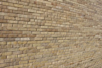 Angle view of an attractive light brown brick wall background with a Flemish stretcher bond pattern