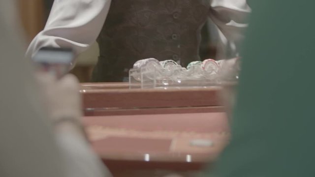 Slow motion shot of cards and chips on velvet poker table in casino. Gambling, luck and addiction concept.