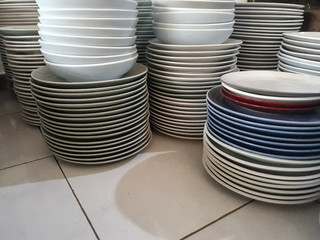stack of plates of cleaned white, blue, red plates for catering buffet in wedding &restaurant room