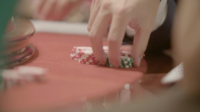 Slow motion shot of cards and chips on velvet poker table in casino. Gambling, luck and addiction concept.