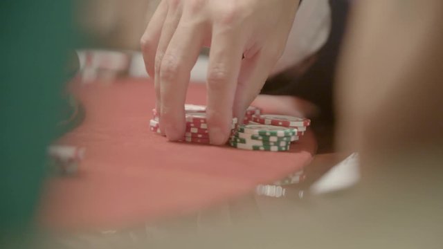 Slow motion shot of cards and chips on velvet poker table in casino. Gambling, luck and addiction concept.