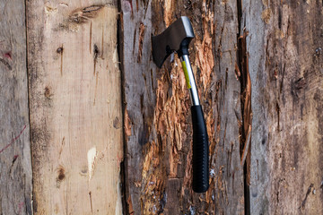 Small axe stuck in a wood board as part of an axe throwing competition