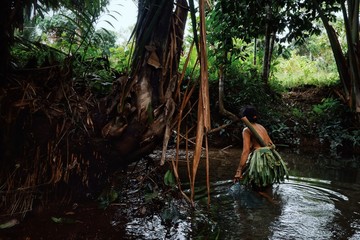 Muara Siberut, Mentawai Islands / Indonesia - Aug 15 2017: tribal member lady fishing for small fry and shrimps in the jungle stream