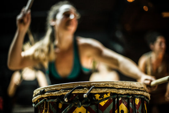 Blurry girl dancing and playing doun doun with two drum sticks