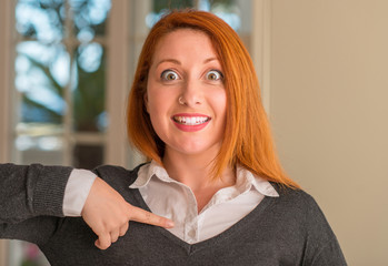 Redhead woman at home with surprise face pointing finger to himself