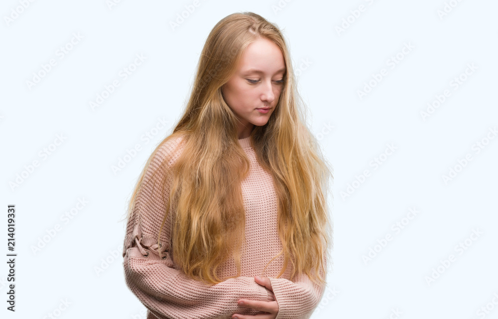 Poster blonde teenager woman wearing pink sweater with hand on stomach because nausea, painful disease feel