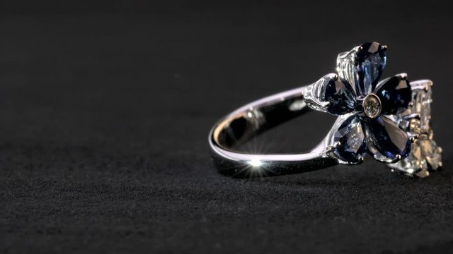 Close-up shot of two sparkling,shining white and blue flower shaped ring with diamonds and saphire jewelery.