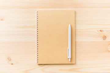 Design concept - Top view of black kraft spiral notebook and mechanical pencil on wood table background for mockup