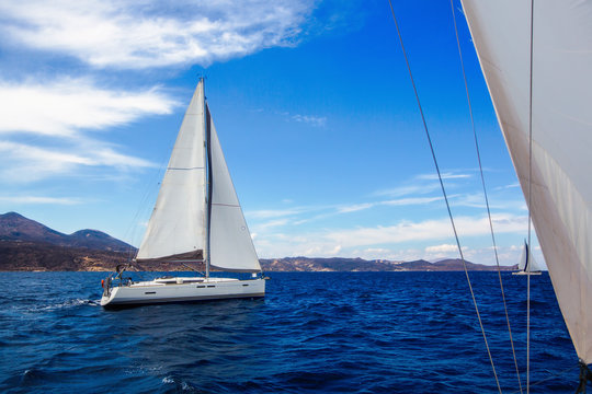 Luxury yachts at sailing regatta in the wind through the waves at Aegean Sea.