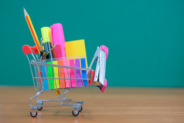 Back to school and Education concepts with shopping cart, pencil, staples, highlighter and notepad