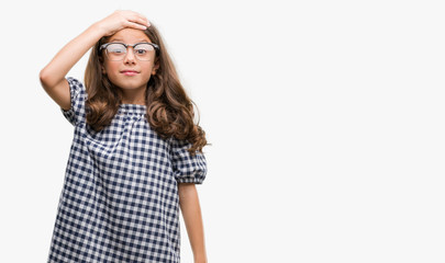 Brunette hispanic girl wearing glasses stressed with hand on head, shocked with shame and surprise face, angry and frustrated. Fear and upset for mistake.