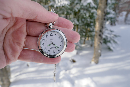 Pocket watch taken in hand in the forest in winter