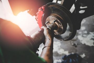 Hand of car mechanic working with tool pneumatic wrench in auto repair service. Repair of wheels