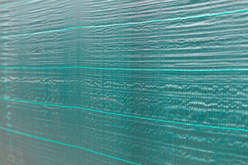 Fototapeta na wymiar green protective net cloth background. building construction site with plastic cover