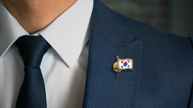 Businessman Walking Towards Camera With Country Flag Pin - South Korea