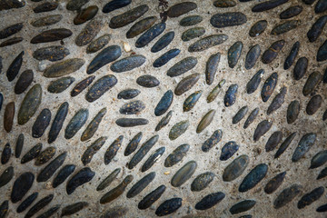 Round stones in the ground, Cobblestones in concrete background.