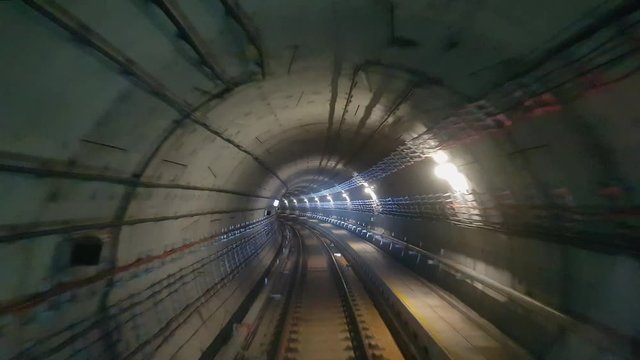 Tunnel view of a subway train traveling from one station to the next.