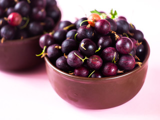 Fresh ripe organic gooseberry in a plate on the table. Summer garden berry close-up.  Summer berries.The gooseberry with drops of water. 