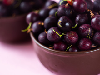 Fresh ripe organic gooseberry in a plate on the table. Summer garden berry close-up.  Summer berries.The gooseberry with drops of water. 