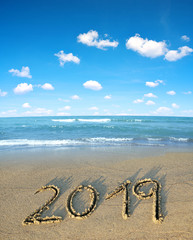 2019 written on the sand of a beach. Travel and New Year concept.