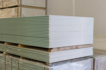 Pallet with plasterboard in the building store. Warehouse with plasterboard. sheets of plasterboard on pallets. Construction Materials. Drywall warehouse. - obrazy, fototapety, plakaty