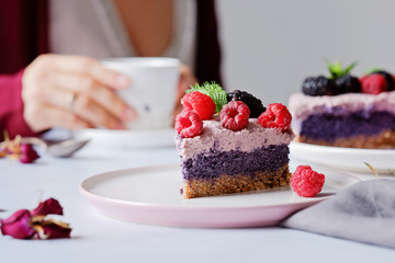 Raw vegan cake with raspberries and bluberries on white table