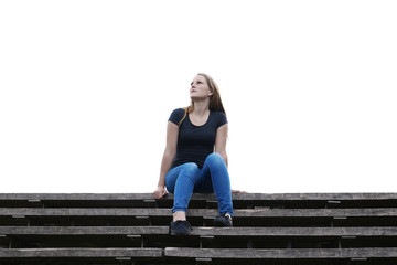 pensive young woman sitting on outside flight of stairs