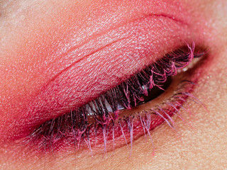 Detalle ojo párpado y pestañas maquillados de mujer rosa
