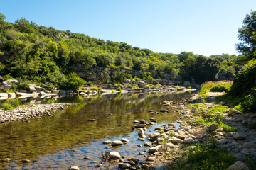Das steinige Flussufer der Ardeche vor dem kleinen Ort Balazuc in Südfrankreich