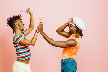 Having fun - portrait of two men holding hands, dancing  and laughing