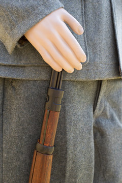 main de mannequin tenant un fusil