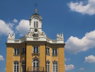 Fototapeta na wymiar Baroque facade of Karlsruhe Residence Palace against blue sky with white clouds, Germany