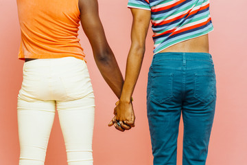 Back view of two young men holding hands