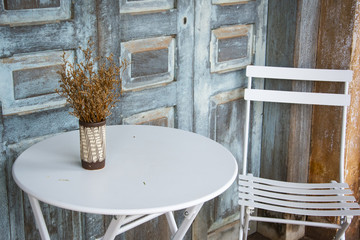 Table and chairs An open terrace in a cafe, shelf in front of wooden door and old house, selective focus, copy space