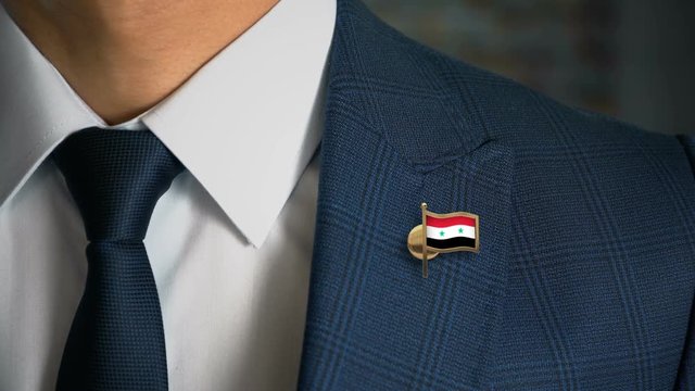 Businessman Walking Towards Camera With Country Flag Pin - Syria