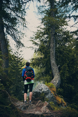 Fototapeta premium Ragazza trekking nel bosco con zaino in spalla