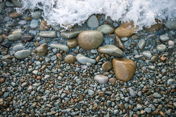 Large stones on the beach, washed by the wave