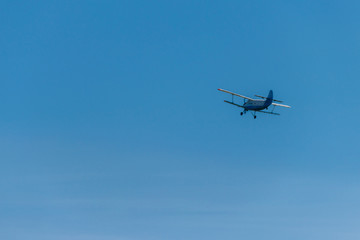 Fototapeta na wymiar Biplane flying in blue sky