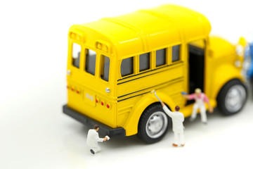 Fototapeta na wymiar Miniature people: Workers brush painting school bus,Back to school concept.