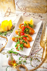 Balkan cuisine. Sea prawns with Mexican salsa on the background of geographical maps, rope and empty bottles. concept sea voyage. Copy space, selective focus