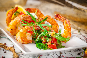 Balkan cuisine. Sea prawns with Mexican salsa on the background of geographical maps, rope and empty bottles. concept sea voyage. Copy space, selective focus
