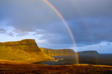 Rainbow over a dramatic coastline of Scottish highlands, Isle of Skye, UK