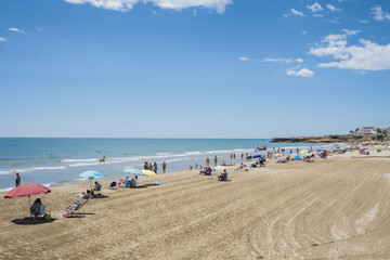 Fototapeta na wymiar Tourist on the beach on a sunny day. Mediterranean coast, sea. Alcossebre, Valencia Spain. 