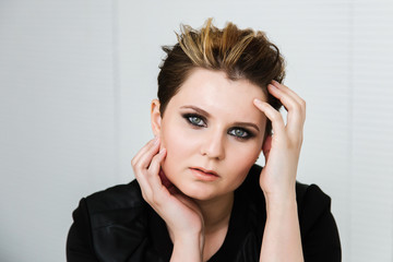 Portrait of a young woman with a short haircut with makeup smoky eyes