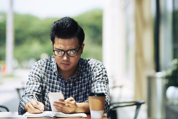 Young man working in outdoor cafe