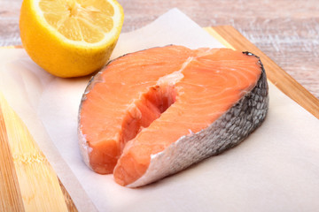 fresh raw salmon with spices and lemon on wooden cutting board. ready for cookin