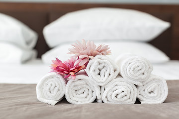 towels and flower on bed in hotel room